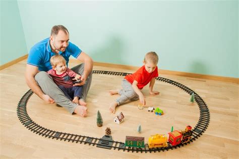 Padre Joven E Hijos Divirtiéndose Juntos La Familia Juega Un Tren De