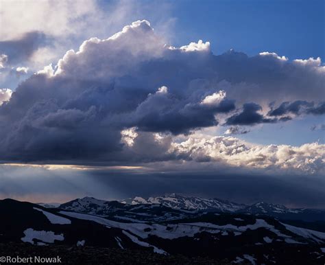 A seascape with fluffy dark clouds and mountain in the horizon. Storm Clouds Over the Never Summer Range | Rocky Mountain ...