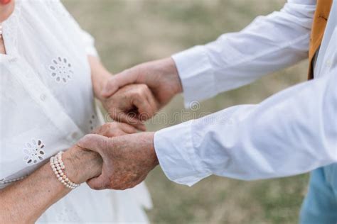 Close Up Of Seniors Hands During Their Marriage In A Garden Stock