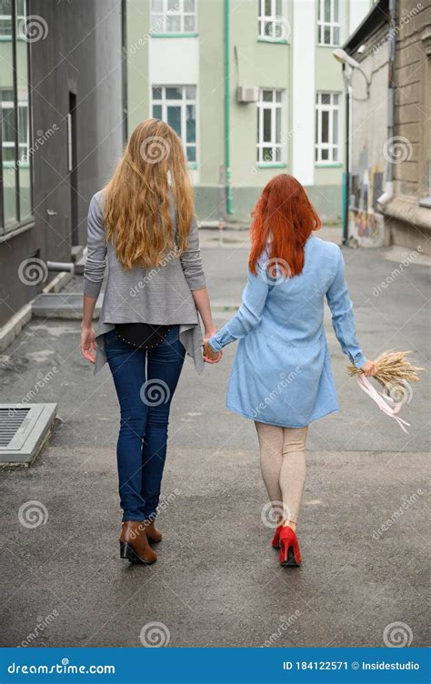 Same Sex Relationships Happy Lesbian Couple Walking Down The Street Holding Hands Stock Image