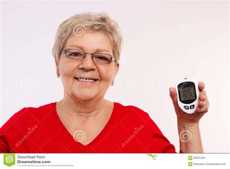 Happy Senior Woman Holding Glucometer Measuring And Checking Sugar