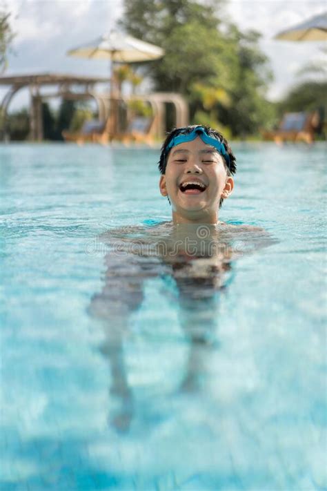 Asian Young Boy Having A Good Time In Swimming Pool He Jumping And