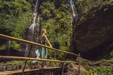 Woman In Turquoise Dress At The Sekumpul Waterfalls In Jungles On Bali