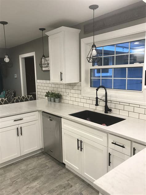 White Shaker Cabinets With Solid Surface Countertops And Flat Black