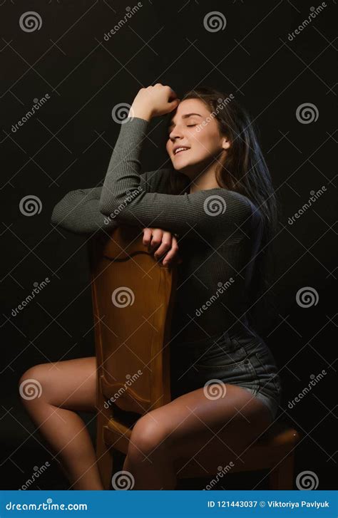 Cheerful Brunette Girl Sitting In Studio During Model Tests Dressed In