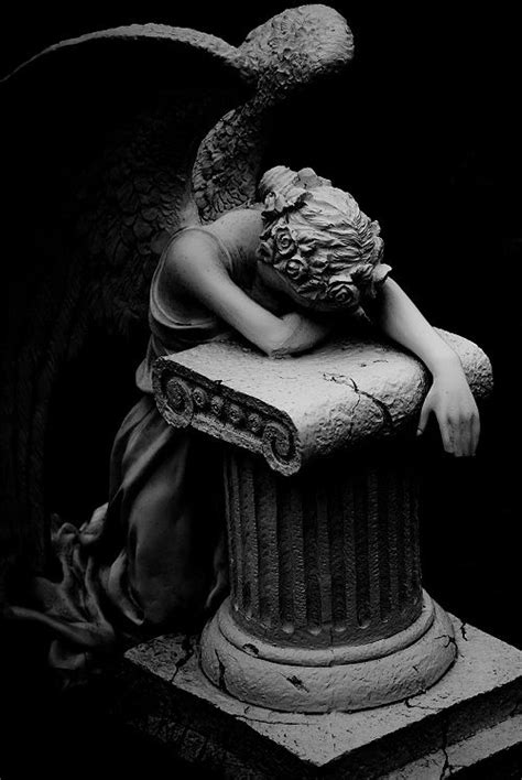 an angel statue sitting on top of a pillar next to a black and white photo