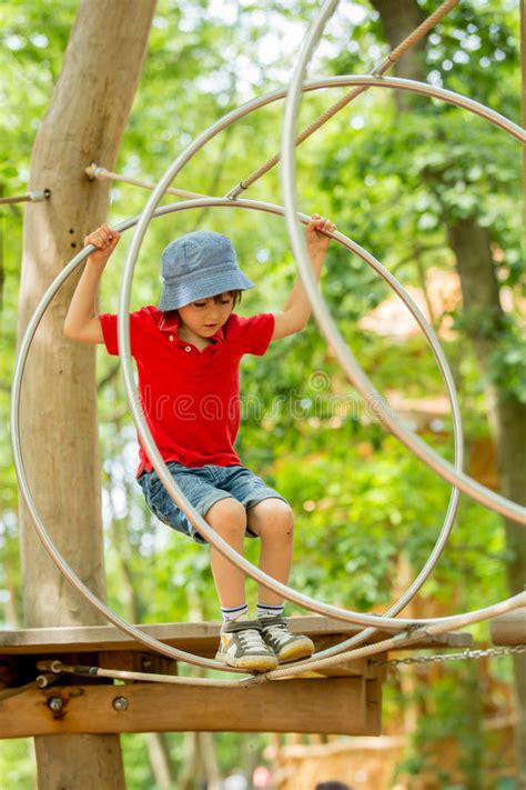 Cute Child Boy Climbing In A Rope Playground Structure Stock Image