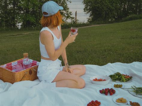Redhead Woman In White Tank Top And White Shorts Sitting On Picnic