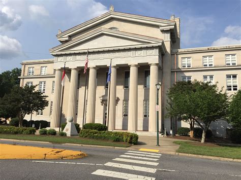 An Old Courthouse Building With Columns And Flags On The Top Floor In