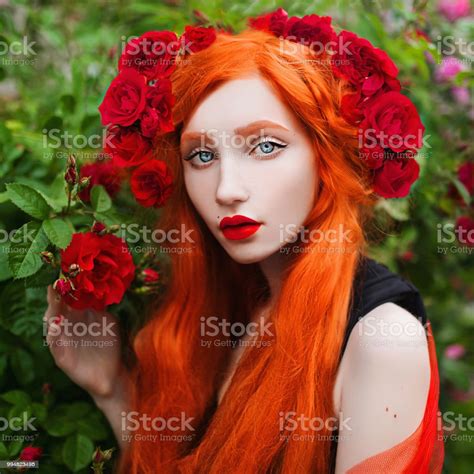Portrait Of Young Unusual Pale Girl With Red Hair In Rose Garden