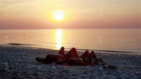 Couple Romantically Lay Under The Sun Together During Sunset On A