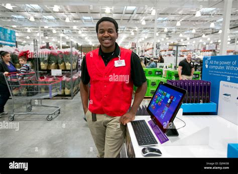 Young African-American male COSTCO employee smiles at new store in