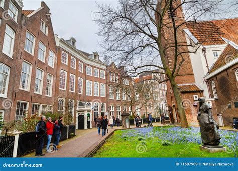 Begijnhof Courtyard With Tourists Statue And Historic Houses In