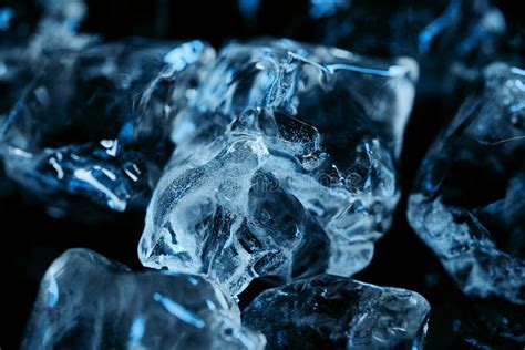 Close Up View Of Frozen Ice Cubes With Blue Lighting On Black Stock