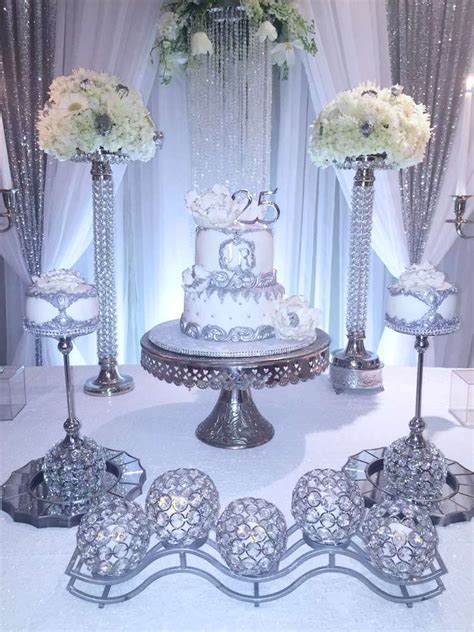 A White Wedding Cake Surrounded By Silver Decorations