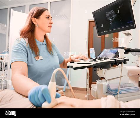 Female Sonographer Examining Woman With Ultrasound Scanner Doctor