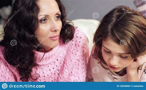 Mother Attentively Listening To Daughter Reading And Remembering Her