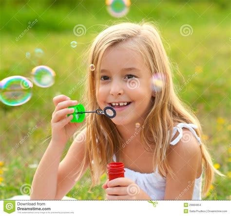 Happy Little Girl Blowing Soap Bubbles Stock Images