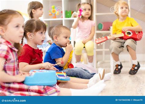Group Of Preschooler Children Playing With Musical Toys At Kindergarten