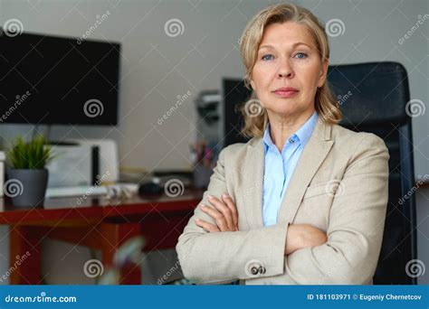 Portrait Of Mature Female Boss Working In Office Sitting In A Chair