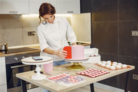 Focused Female Pastry Chef Preparing Cake And Desserts With Smartphone