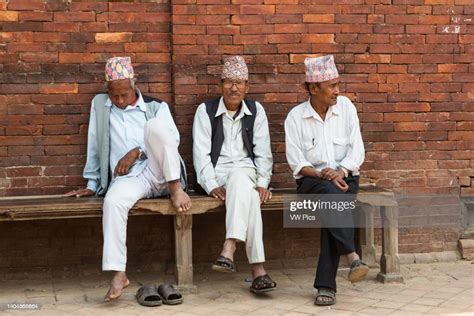 three older nepali men wearing traditional dhaka topi hats sit on a news photo getty images