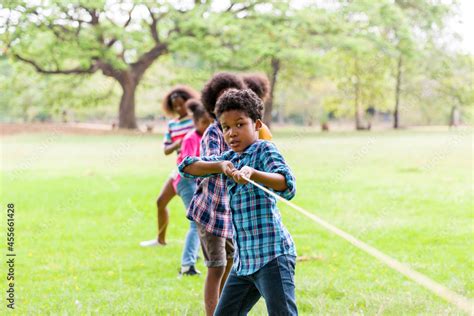 Group Of African American Boy And Girl Playing Tug Of War Together In