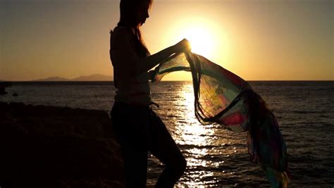 Woman Walking On Beach At Sunset Wearing Sarong While On