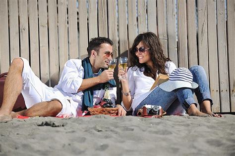 A Romantic Picnic On The Beach Young Couple Delights In Each Others
