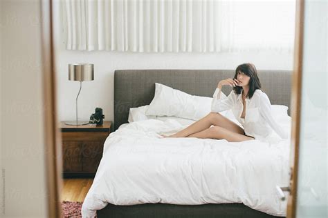 A Candid Portrait Of A Woman Sitting On A Bed By A Model Photographer