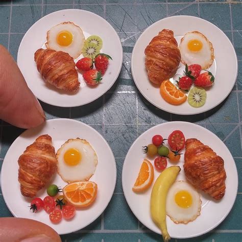 Three White Plates Topped With Croissants Fruit And An Egg On Them