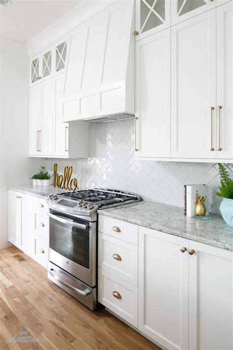 I'm noticing a design trend of differentiating between cabinet doors and drawers with pulls and knobs. White Kitchen Cabinets with Champagne Gold Hardware ...