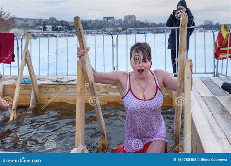 Woman Bathes Into Cold Water Of Ice Hole On Epiphany Day Traditional