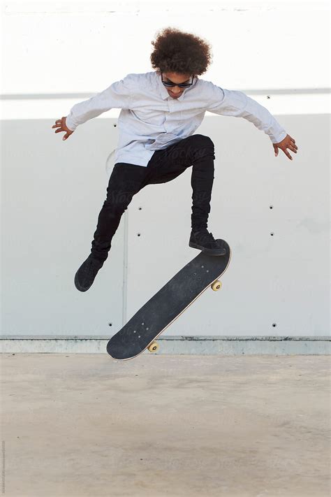 Portrait Of An Afro Black Skater Man Jumping By Stocksy Contributor