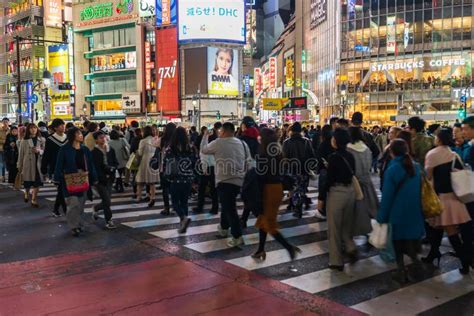 Crowds Of People Walking Across At Shibuya Famous Crossing Street In