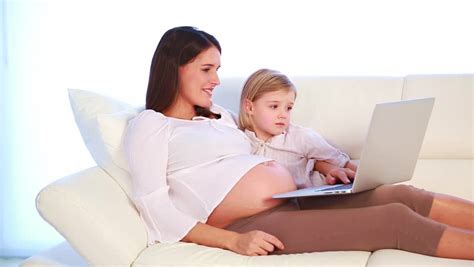 Pregnant Woman Sitting On White Sofa Have Relax With Her