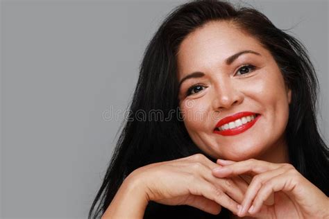 close up of beautiful mature woman with beautiful smile isolated on light grey background wall