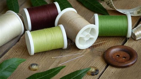 Spools Of Thread With A Button Sewing Needles And A Measuring Tape