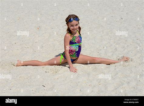 Junges Mädchen Macht Den Spagat Auf Dem Sand Am Strand Stockfotografie