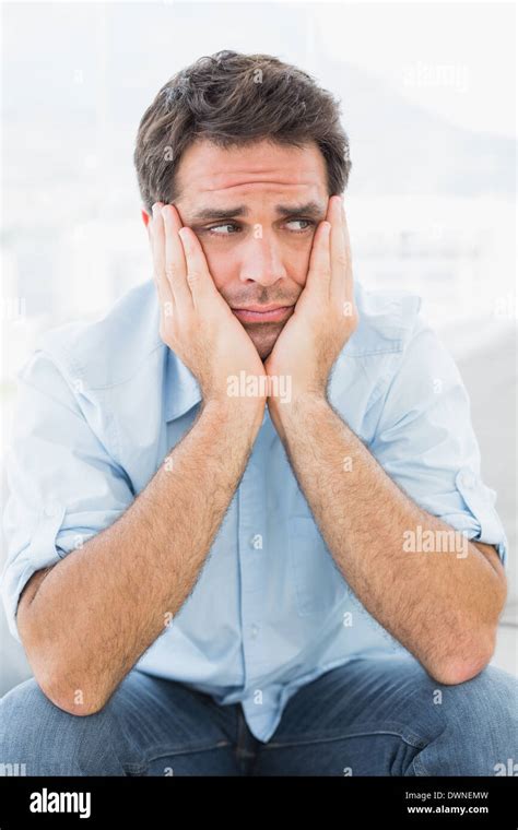 Sad Man Sitting On The Couch Looking Away Stock Photo Alamy