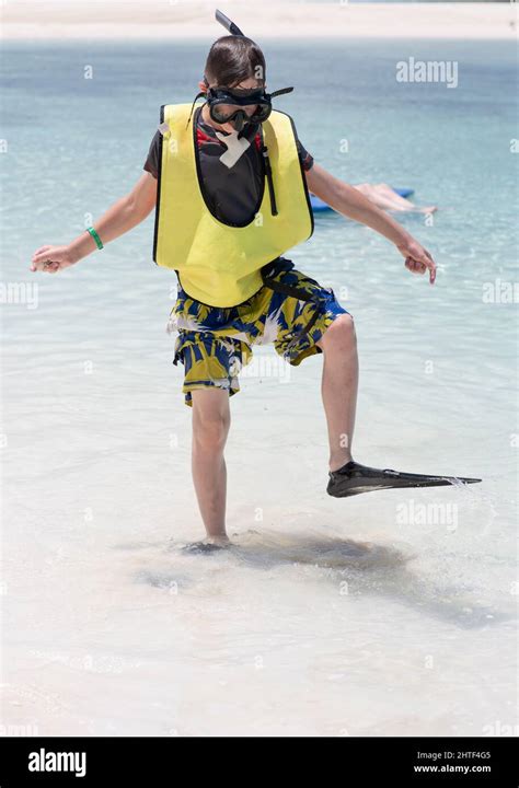 Young Boy Walking In Fins In Shallow Water Wearing Snorkel Gear Stock