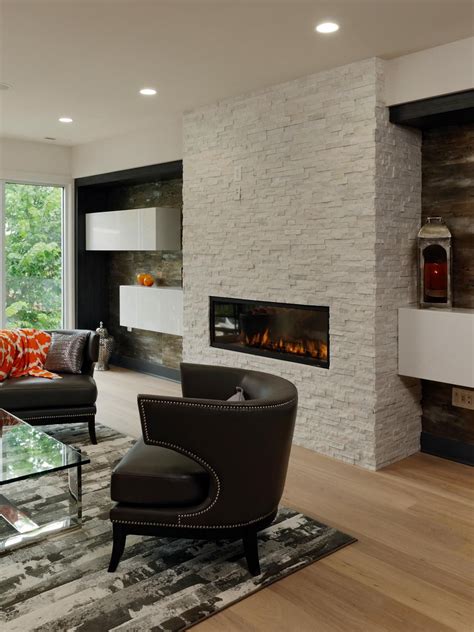 Empty living room in luxurious home. Floating shelves on either side of this white stone ...