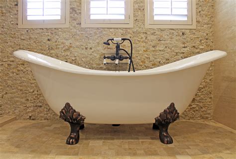 Freestanding Tub With Bronze Legs And Natural Stone Tile Bathroom