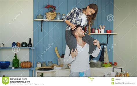 Happy Young Couple Having Fun In Kitchen At Home Girl Is Sitting On