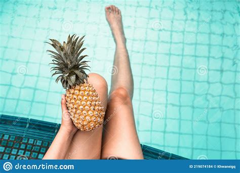 Woman Is Relaxing In Swimming Pool While Holding Pineapple Close Up Of Beautiful Woman Hold