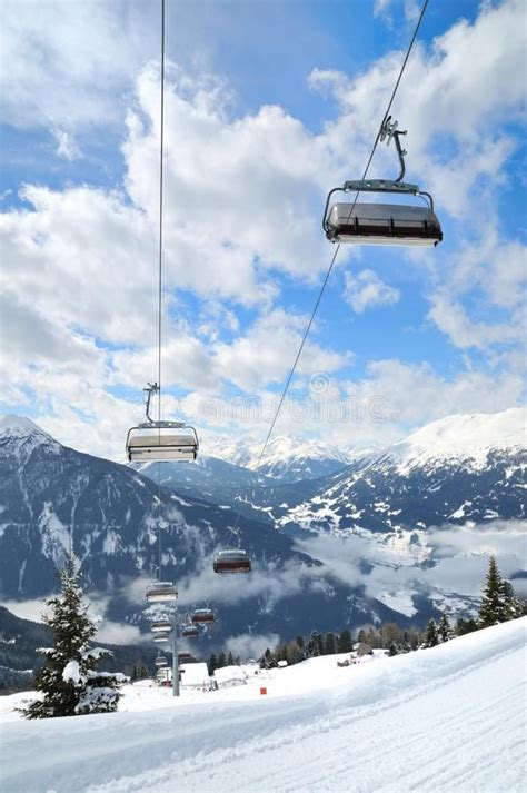 A Ski Lift Is Above The Snow Covered Mountains And Clouds In The Sky