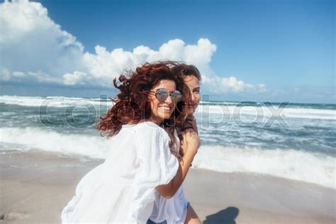 Two Friends Walking On The Beach And Stock Image Colourbox