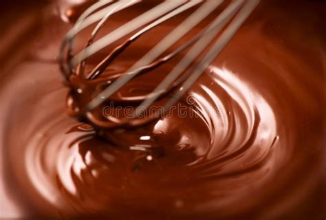 cioccolato cioccolato fondente fuso mescolantesi con una sbattitura primo piano del turbinio