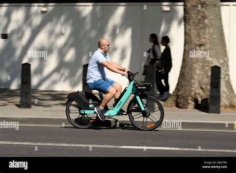 A Man Cycling A Tier Electric Hire Bicycle Along Whitehall London Uk