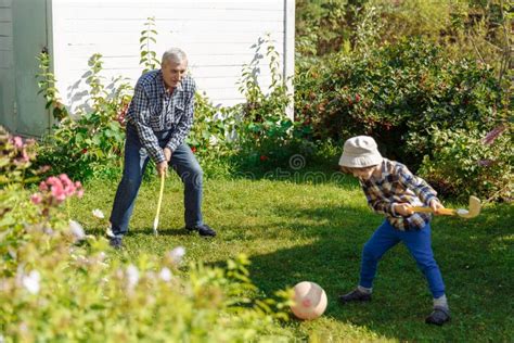 Grandfather Plays With His Grandson In Nature In Summertime Elderly